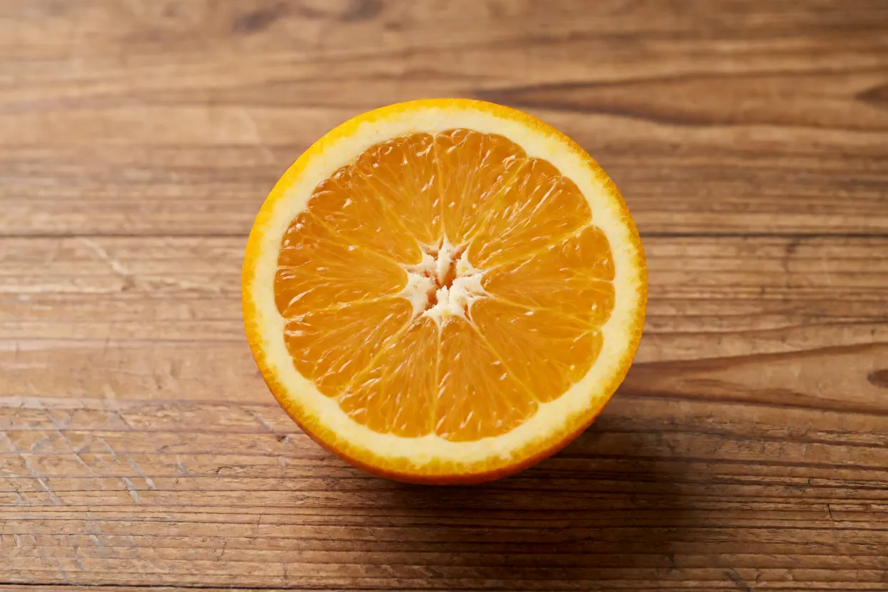 Laranja cortada ao meio mostrando gomos suculentos